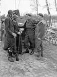 Captain G.B. Shellon, Intelligence Officer of the 10th Canadian Infantry Brigade, and Lieutenant R.C. McNairn of the Pioneer Platoon, Algonquin Regiment, talking with Dutch civilians near the Belgium-Netherlands border, 16 October 1944 16-Oct-44