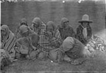 [Group of Indigenous peoples seated on the ground]. Original title: Indians [graphic material] 1933