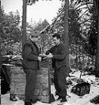 H./Capt. Joe Cardy, padre of the Essex Scottish, giving a cigarette to Pte. Tom Holmes 24 Jan. 1945
