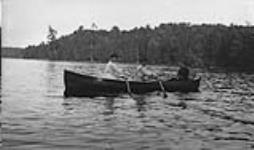 Three unidentified women in a rowboat ca. 1907