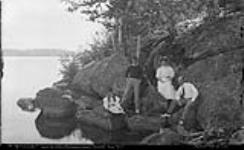 Unidentified group near edge of riverbank, Maplehurst, Muskoka Lakes Aug. 1907