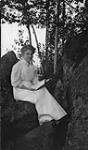 Unidentified woman sitting on rock ca. 1907