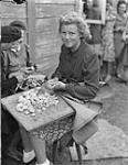 2nd Canadian Corps. Demobilization of high ranking Nazi officers and officials in internment camp. Former secretary to Gestapo Chief at Wilhelmshaven dicing potatoes 8 June 1945