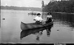Two unidentified women in canoe ca. 1908
