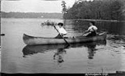 Two unidentified women in canoe ca. 1908