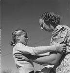 In a scene from the National Film Board production "Mercy Flight" news is brought to Mrs. Carl Wells by her daughter Anna that her husband has been injured in a tractor accident in the field Oct. 1947