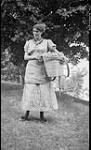 Unidentified young woman with basket. Dominion Council Y.W.C.A., Elgin House, College Day, Muskoka Lakes 1 July 1909