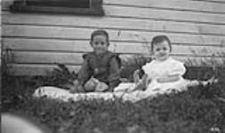 Two unidentified young children on lawn ca. 1909