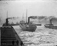 Stern view of laker SUPERIOR of Buffalo, N.Y., in ice at approaches to canal, surrounded by other lake ships 1913