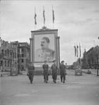 CANADIANS IN GERMANY. 'Little Joes' of the Argyll & Sutherland Highlanders sightseeing. With Stalin's huge picture in background near the Brandenburg Gate are l. to r.: Ptes G. Backer and W. Weiler,Sgt. C. Elliott and Pte. Bernard Barnes 20-Jul-45