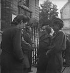 Frenchwomen in uniforms talking with civilians 11-Jul-44