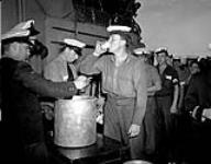 Splicing the mainbrace: Ordinary Seaman Ernest Weir receives an extra rum ration during Victory over Japan celebrations aboard H.M.C.S. PRINCE ROBERT, Sydney, Australia, 16 August 1945 August 16, 1945.