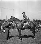 Gunner A.E. Bavington of the 4th Anti-Tank Regiment, Royal Canadian Artillery (R.C.A.) riding Trixie from the Maroon Hunt Club, winner of the third race during a meet held by The British Columbia Dragoons, Veendam, Netherlands, 5 August 1945 August 5, 1945.