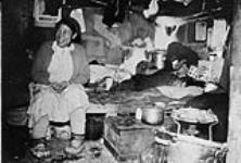 [Inuk woman, Martha Eetak, inside her home] Inuit woman inside shack Apr. 1963.