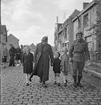 Sergeant L.K. Woods, 6th T.C.A. [6th Field Regiment, Royal Canadian Artillery (R.C.A.)?], and Private M.S. Perkins, Royal Canadian Army Service Corps (R.C.A.S.C.), with Belgian children, Furnes, Belgium, 9 September 1944 September 9, 1944