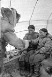 Father Van de Velde with an Inuit woman and a girl inside a tent 1951.
