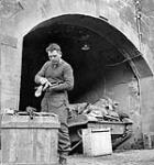 Private M. Bulyea of the Calgary Highlanders cleaning his Bren light machine gun, with his Universal (Bren Carrier) Carrier in the background, Fort de Schooten, Belgium, 4 October 1944 04-Oct-44