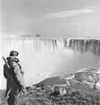 Horseshoe Falls, Canadian side of Niagara Falls, with Reggie Thompson of Hamilton, New Brunswick, on guard. Falls are protected by barbed wire and military guard Mar. 1944