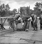 Lance-Corporal A.A. Shaylor of No.2 Provost Company, Canadian Provost Corps, and members of the Royal Canadian Engineers (R.C.E.) assisting Belgian refugees to cross a Bailey Bridge over the Albert Canal, Belgium, 28 September 1944 September 28, 1944.