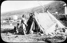 Femme inuite devant une tente estivale faite de peaux ca. 192-