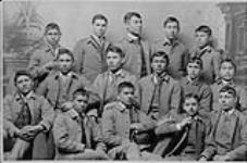 [Portrait en studio de quinze étudiants en uniforme scolaire, Carlisle Indian Industrial School] vers 1888.