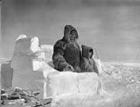 [Joseph Pork Kangiryuaq and Alex Ikkat Uqqaat, stand outside an igloo][ Kunegeynek and his grandson Ikket of Baker Lake stand outside an Igloo [The man has also been identified as Kigusiutnaq] March 1946.