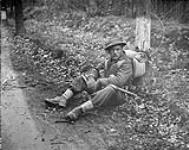 Private N.J. Ingram, Perth Regiment, stops for a rest north of Arnhem, Netherlands, 15 April 1945 April 15, 1945.