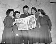 A group at SHAEF Headquarters reading the special VE-Day edition of the MAPLE LEAF newspaper, Paris, France, 11 May 1945 May 11, 1945