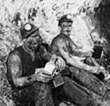 Cecil Roberts and his brother Charlie eating lunch about 2.5 miles out under the Atlantic 800 feet below the ocean floor Aug. 1946