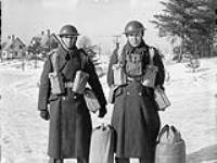 Unidentified Canadian soldiers, who are wearing greatcoats, web equipment, and steel helmets, Petawawa, Ontario, Canada, 1943 1943.