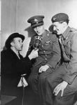 A Canadian Broadcasting Corporation reporter interviewing two parachute-qualified officers, one from the Royal 22e Régiment, who are part of the First Rotation Leave, Halifax, Nova Scotia, Canada, 8 December 1944 December 8, 1944.