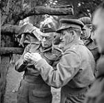 Major S.J. Hawkins, a British mine instructor, showing a component of a German mine to Lieutenant-General A.G.L. McNaughton, Kilmarnock, Scotland, 8 June 1943 June 8, 1943