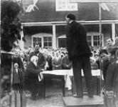 A typical religious service at Brilliant, British Columbia. On platform is Peter Petrovich Verigin. Seated is Paul Ivanovich Buirikov. 1927 1927