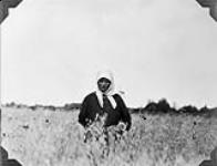Mrs. Dowhan picking various weeds out of her excellent crop of oats. Manitoba 1928