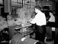 Men pressing Canadian Army uniforms in large clothing factory déc. 1939