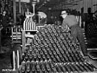 Des centaines de douilles de fusil-mitrailleur Bren sont soigneusement empilées dans une usine de munitions du Canada en attente des derniers essais Dec. 1939
