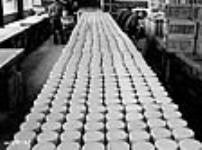 Des ouvriers emballent des balles de fusil-mitrailleur Bren dans des caisses d'expédition à la fabrique de munitions National Steel Car Corporation Ltd Dec. 1939