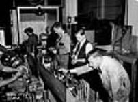 Des ouvriers examinent des obus antiaériens de 40 mm juil. 1940