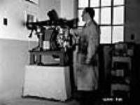 Un technicien d'essai tire une balle de fusil-mitrailleur Bren dans une salle d'essai spéciale juil. 1940