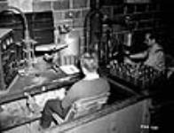 Des ouvriers fabriquent des masques à gaz dans la salle d'assemblage de l'édifice de l'annexe de recherche 17 Ot. 1940