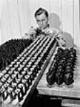 Ouvrier peinturant une goupille de grenade à main à l'usine Frost and Wood Apr. 1941