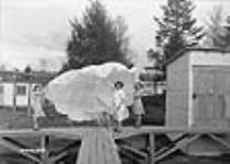 Des employées étalent un parachute fabriqué par la société International Flare Signal Co May 1941