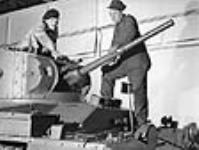 Aux ateliers Angus, un mécanicien militaire montre un élément d'un char d'assaut à un ouvrier affecté à la fabrication de ces chars 23 mai 1941