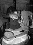 Un ouvrier examine la poudre utilisée pour fabriquer les écrans de fumée utilisés par les avions et navires de guerre à l'usine de la Shawinigan Chemicals July 1941