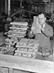 Un ouvrier finit la crosse en bois d'un fusil dans une usine d'armes légères à Long Branch juil. 1941