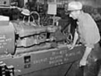 Un ouvrier fait fonctionner une machine d'usinage des crosses en bois pour fusil dans une usine d'armes légères à Long Branch juil. 1941