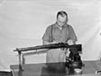 Un ouvrier assemble un fusil presque terminé dans une usine d'armes légères à Long Branch juil. 1941