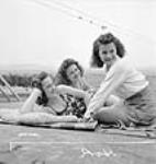 French-Canadian women Dominion Arsenals Ltd. munitions workers enjoying a leisurely day sun-tanning 24 août 1942