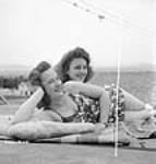 French-Canadian women Dominion Arsenals Ltd. munitions workers enjoying a leisurely day sun-tanning 24 Aug. 1942