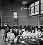 Des ouvrières de l'atelier de munitions de l'usine Dominion Arsenals Ltd., s'assoient pour profiter de leur demi-heure de pause 24 Aug. 1942